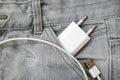 Usb charger, wire and adapter plug in grey jeans pocket, dont forget charger at home Royalty Free Stock Photo