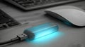 USB Device Glowing Blue on a Wooden Desk Next to a Computer Mouse and Keyboard in a Modern Workspace Royalty Free Stock Photo