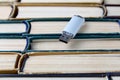 USB flash card on the background of a large stack of old shabby books. Portability of modern information storage media Royalty Free Stock Photo