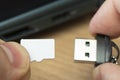 usb flash drive adapter micro sd card connection to laptop. micro sd card in man's hand Royalty Free Stock Photo