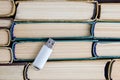 usb flash drive on background of stack of paper books Royalty Free Stock Photo