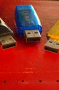 USB flash drive - black, yellow and blue, on a red background. Three used computer flash drives, ready to work. Close-up of a data Royalty Free Stock Photo