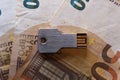 USB flash drive in the form of a key and banknotes on the table Royalty Free Stock Photo