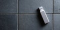 A USB flash drive with a textured grip and white connector end on top of grey tiles Royalty Free Stock Photo