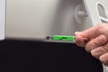 USB Green flash memory connected by hand to a monitor