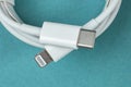 Usb lightning white data cable on green, isolate, copy space Royalty Free Stock Photo