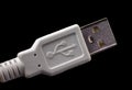 USB plug on a white cable with logo. Standard type A male connector isolated on black Royalty Free Stock Photo