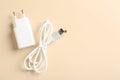 USB power adapter and charge cable on beige background, flat lay. Space for text Royalty Free Stock Photo