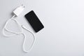 USB power adapter with charge cable and smartphone on white background, flat lay. Space for text Royalty Free Stock Photo