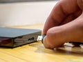 USB type 3.0 HDD, man inserting a cable into a portable external hard drive, object detail, hand extreme closeup. Digital data