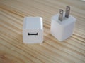 Usb white-cube charger on wooden board with technology and energy concept To facilitate