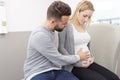 usband and pregnant woman expecting birth sitting on couch Royalty Free Stock Photo