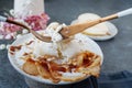 Use a fork and knife to cut the burrata. Burrata cheese served with baked caramelized pear and pine nuts. Close-up