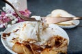 Use a fork and knife to cut the burrata. Burrata cheese served with baked caramelized pear and pine nuts. Close-up