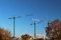 Use of high tower frame metal cranes in construction. Panorama of the development of the city against the blue sky. Work in real e Royalty Free Stock Photo