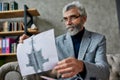 Use imagination. Mature psychologist holding picture with ink stain, Rorschach Inkblot during therapy session. Soldier