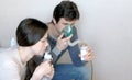 Use nebulizer and inhaler for the treatment. Man and woman inhaling through inhaler mask. Closeup side view.