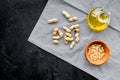 Use nut oil as cosmetics. Peanut oil in jar near peanut in bowl on blue tablecloth on black background top view copy Royalty Free Stock Photo