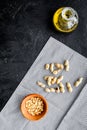 Use nut oil as cosmetics. Peanut oil in jar near peanut in bowl on blue tablecloth on black background top view copy Royalty Free Stock Photo