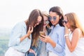 Use of smartphones, the Internet, applications and messages. A group of beautiful girls look at the phone girlfriend and laugh