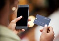 Use your phone to simplify your life. a young woman using her smartphone to make card payments.