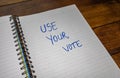 Use your vote, handwriting text on paper, political message. Political text on office agenda. Concept of democracy, voting,