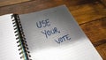 Use your vote, handwriting text on paper, political message. Political text on office agenda. Concept of democracy, voting,