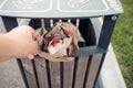 Used bags from food purchased at a McDonald`s fast food restaurant . Environmental pollution, a woman`s hand throws garbage into