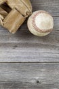 Used baseball and weathered mitt on old wood Royalty Free Stock Photo