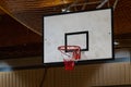 Used basketball backboard, hoop, net inside of basketball court, Right side view