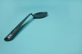 A used and bent spoon, on a blue background.