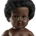 Used black doll in front of a white background