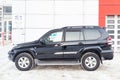 Used black Toyota Land Cruiser Prado 2007 release with an engine of 4 liters side view on the car snow parking after preparing for