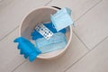 Used blue medical latex gloves and disposable protective masks in the bin. Problem of the disposal of contagious personal