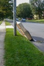 Used box spring mattress leaning against a utility pole left on the side of a street waiting for trash pickup