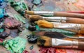 Used brushes on an artist's palette of colorful oil paint for dr Royalty Free Stock Photo