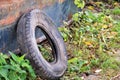 Used car tire left in nature. Old used car tyre left tossed by cost of water. Royalty Free Stock Photo