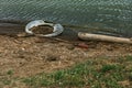 Used car tires remained in nature. The old unnecessary tire of car remained in the water. The problem of recycling waste, garbage Royalty Free Stock Photo