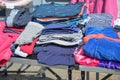 Used casual clothes in blue, white and pink for sale at a flea market stall on a sunny day Royalty Free Stock Photo