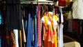 Used clothes of various colors displayed in a stall in the second-hand market of Porta Portese in Rome