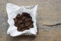 Used coffee grounds in white paper tissue in square glass ashtray on wooden board Royalty Free Stock Photo