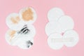 Used cotton pads and cotton swabs. Dirty and clean cosmetic pad after removing make-up. Pink background. Flat lay. Dirty