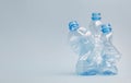 Crushed pet plastic bottles on blue background, recycling and environment concept Royalty Free Stock Photo