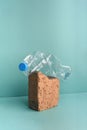 Used crushed plastic bottle on brick stone on blue background.