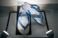 Used and dirty white flip flops on black and white display Royalty Free Stock Photo