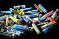 Used disposable drain batteries of various size and color on black background