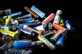 Used disposable drain batteries of various size and color on black background