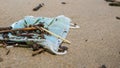 Used disposable mask is on a beach during Coronavirus COVID-19