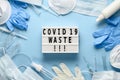 Used disposable medical face masks, latex gloves, syringes, test tubes on pastel blue background. COVID-19 waste Royalty Free Stock Photo