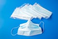 Used disposable and new in packaging medical mask on a blue background